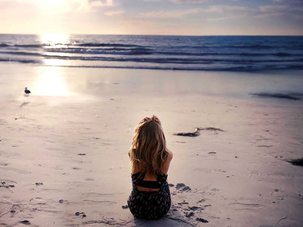Девушка на берегу моря спиной