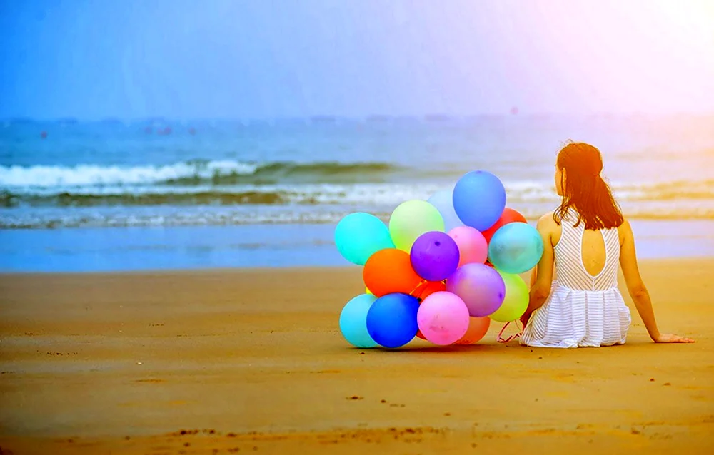 Девочка с шариками на море