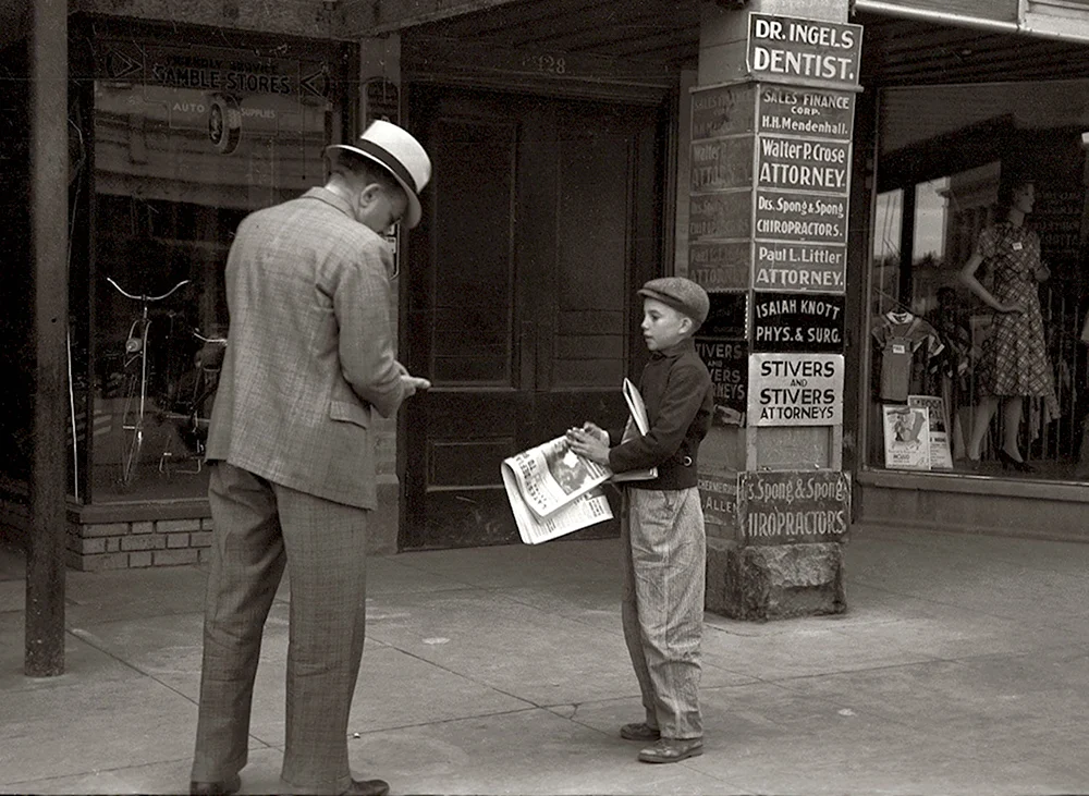 Мальчик продает газеты