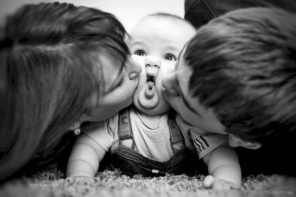 Родиьели целуют малышка
