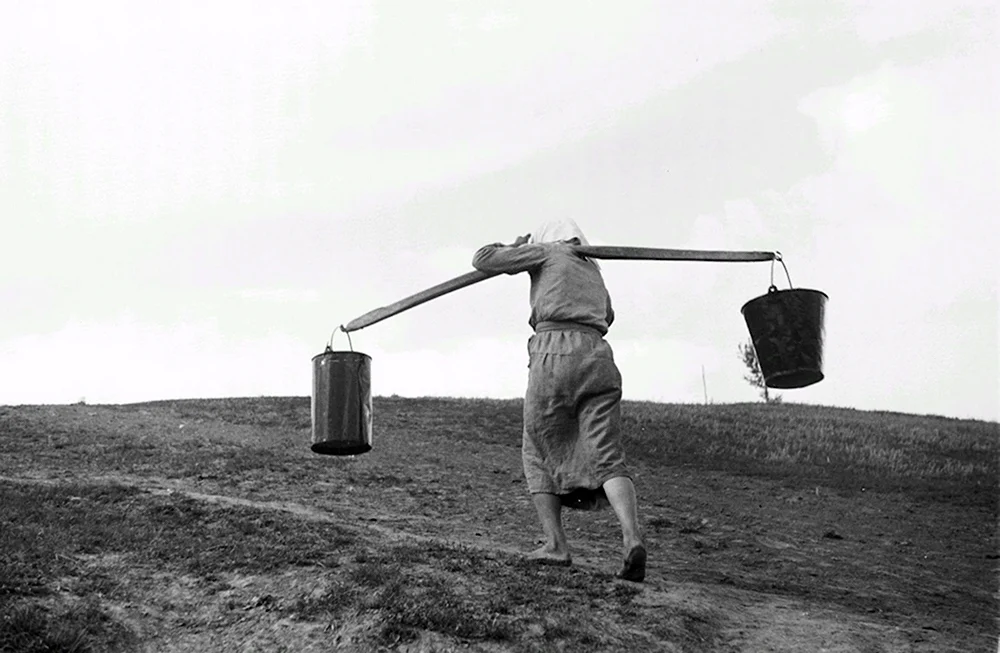 Женщина несет воду